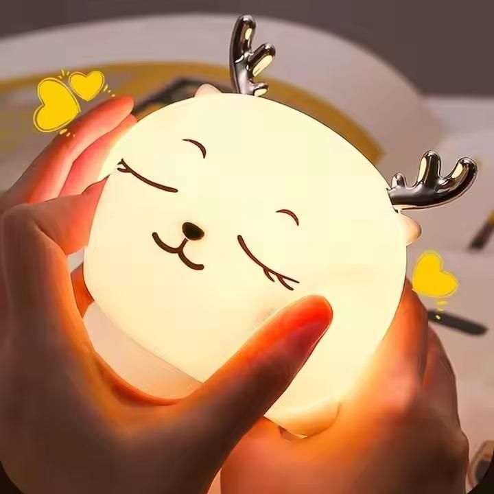 Cute moon-shaped night light with deer antlers held by a hand.